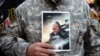 Иранский военный на демонстрации в память о погибшем Касеме Сулеймани, с его портретом в руках. Тегеран, 3 января 2020 года