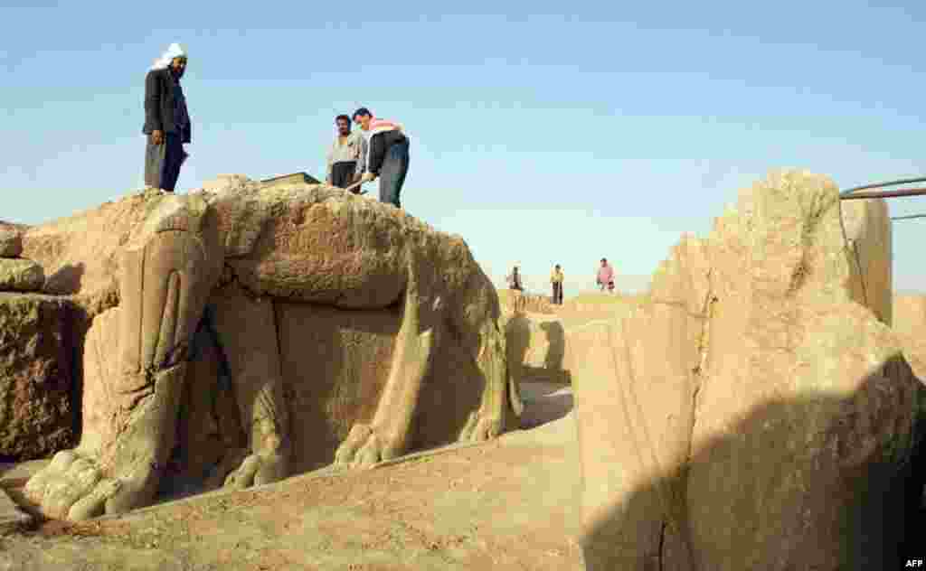 Workers clean a partially preserved statue in 2001.