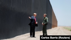 Президент Дональд Трамп беседует с директором Пограничного патруля США Родни Скоттом во время осмотра участка разделительной стены на американо-мексиканской границе в Сан-Луисе, штат Аризона. 23 июня 2020 года