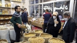 Iranians wearing face masks and protective gloves shopping ahead of the Persian New Year Nowrouz at the grand bazaar in Tehran, March 18, 2020