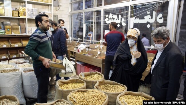 Iranians wearing face masks and protective gloves shopping ahead of the Persian New Year Nowrouz at the grand bazaar in Tehran, March 18, 2020