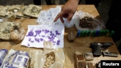 Kyrgyz policemen inspect drugs and weapons, suspected to have been used during ethnic clashes, seized in raids in the city of Osh. (file photo)