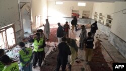 Pakistani security officials gather at a Shiite Muslim mosque after a bomb explosion in Shikarpur in the southern Sindh province on January 30.