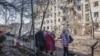 Local residents stand outside damaged buildings at the site of an air attack in Slovyansk in eastern Ukraine on March 10. 