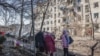 Local residents stand outside damaged buildings at the site of an air attack in Slovyansk in eastern Ukraine on March 10. 