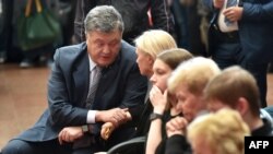 Ukrainian President Petro Poroshenko talks with relatives as he pays a tribute to Belarus-born journalist Pavel Sheremet, who was killed in a car bomb in central Kyiv on July 20.