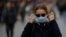 A woman adjusts her protective face mask as she walks along a street amid the outbreak of the coronavirus disease (COVID-19) in Kyiv.