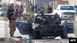 A soldier stands next to the site of a car-bomb attack in Kabul on November 13.