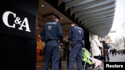 Rendőrök ellenőrzik a vásárlók oltottsági igazolását Bécsben 2021. november 16-án, miután a kormány kormány zárlatot rendelt el a koronavírus ellen teljesen be nem oltott nagyjából kétmillió emberre.