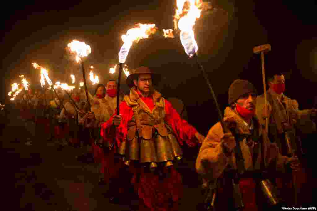 Bulgarian dancers wearing costumes perform a ritual dance with flaming torches during the Kukeri Carnival in the village of Dolna Sekirna on January 13. (AFP/Nikolay Doychinov)