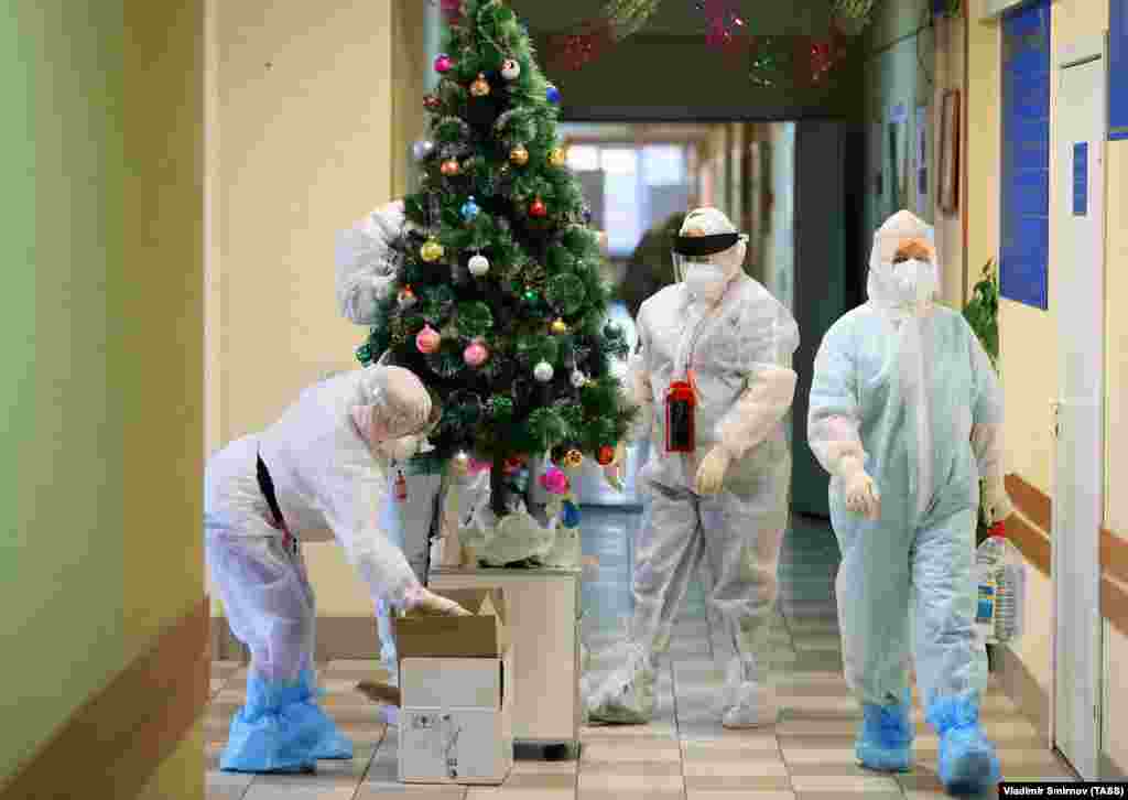 Медици в предпазно облекло украсяват елха в болницата в Иваново, в която лекуват и пациенти с COVID-19.
