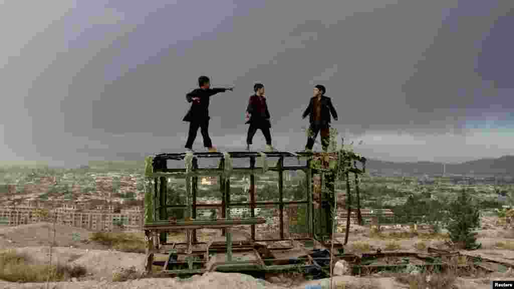 OCTOBER 19, 2012 -- Afghan boys play on the skeleton of an old truck on a hilltop overlooking Kabul. (Reuters/Mohammad Ismail)