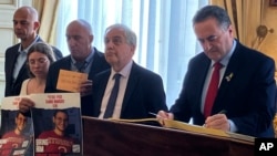 Ministrul de Externe israelian Israel Katz (în dreapta) semnând într-o carte de onoare la Senatul Franței, la Paris, pe 22 mai, chiar în ziua când alte trei țări europene au recunoscut, spre furia sa, statul palestinian. 