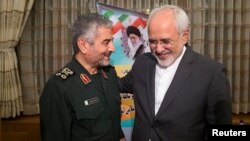 Islamic Revolutionary Guard Corps (IRGC) commander Mohammad Ali Jafari (L) and Iranian Foreign Minister Mohammad Javad Zarif smile during a coordination meeting for the 40th anniversary of the Islamic Revolution, in Tehran, October 9, 2017