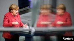  Angela Merkel német kancellár magyaráz a berlini Bundestagban, 2020. december 9-én. 