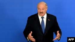 Belarusian President Alyaksandr Lukashenka speaks with journalists at a polling station in Minsk on October 11.