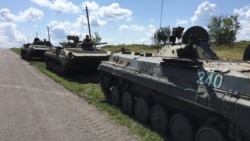 Pro-Russian separatists assemble on July 16 on the field where MH17 crashed almost one year ago, killing all 298 on board.