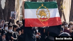 Іранські студенти під час протесту тримають прапор, який використовувався як прапор країни до Ісламської революції 1979 року