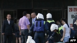 Russia -- Russian Emergency Ministry servicemen help an injured woman aftern explosion in Stavropol, 26May2010