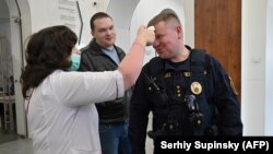 Cadrele medicale iau temperatura agenților de pază din primăria orașului Kiev, 13 martie 2020