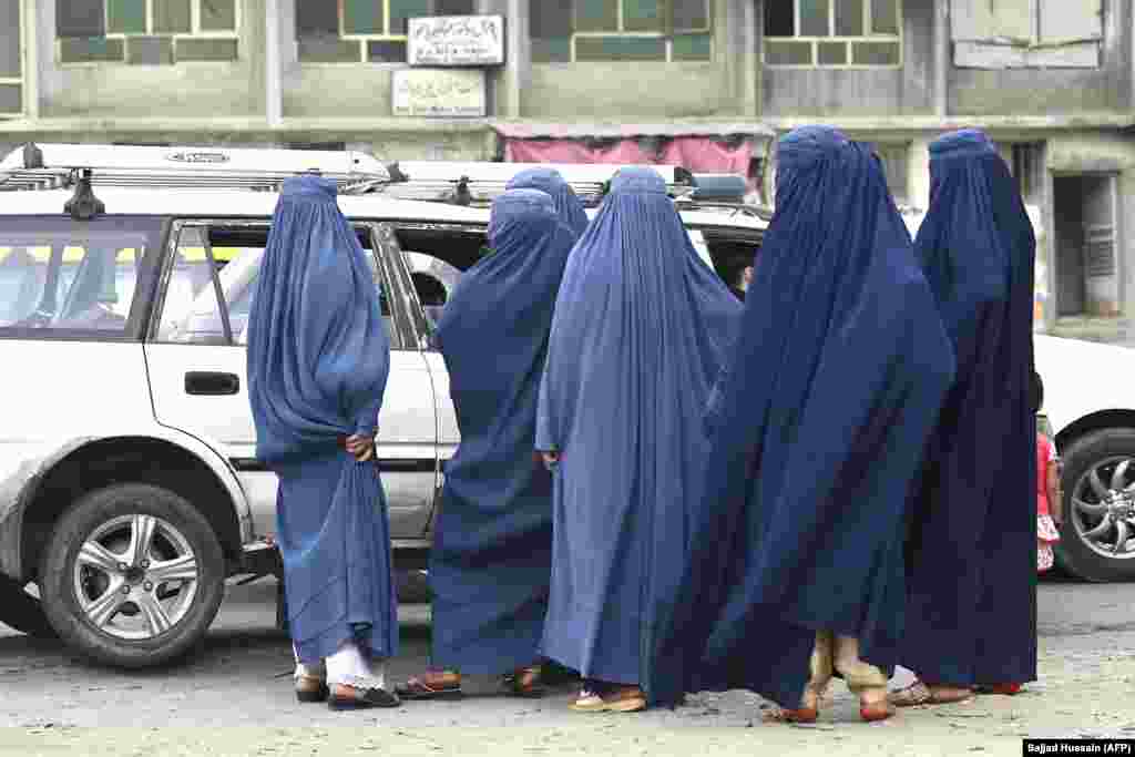 Women wait to enter a taxi in Kabul on July 31. &nbsp; But as the Taliban rapidly take territory from the government and put draconian restrictions on women&#39;s freedom as they go, the prices for burqas are reportedly rising sharply, especially in the western Herat Province.