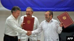 Президент Колумбии Хуан Мануэль Сантос и лидер группировки FARC обмениваются рукопожатием. Гавана, 23 июня 2016 года.