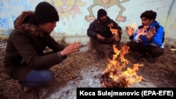 Migrants sit around a fire inside an abandoned warehouse near Serbian border with Croatia on December 23. 