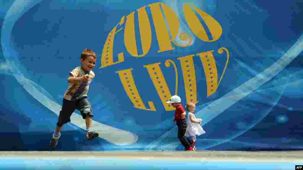 Children play in front of a Euro 2012 poster in Lviv, Ukraine. (AFP/Anne-Christine Poujoulat)