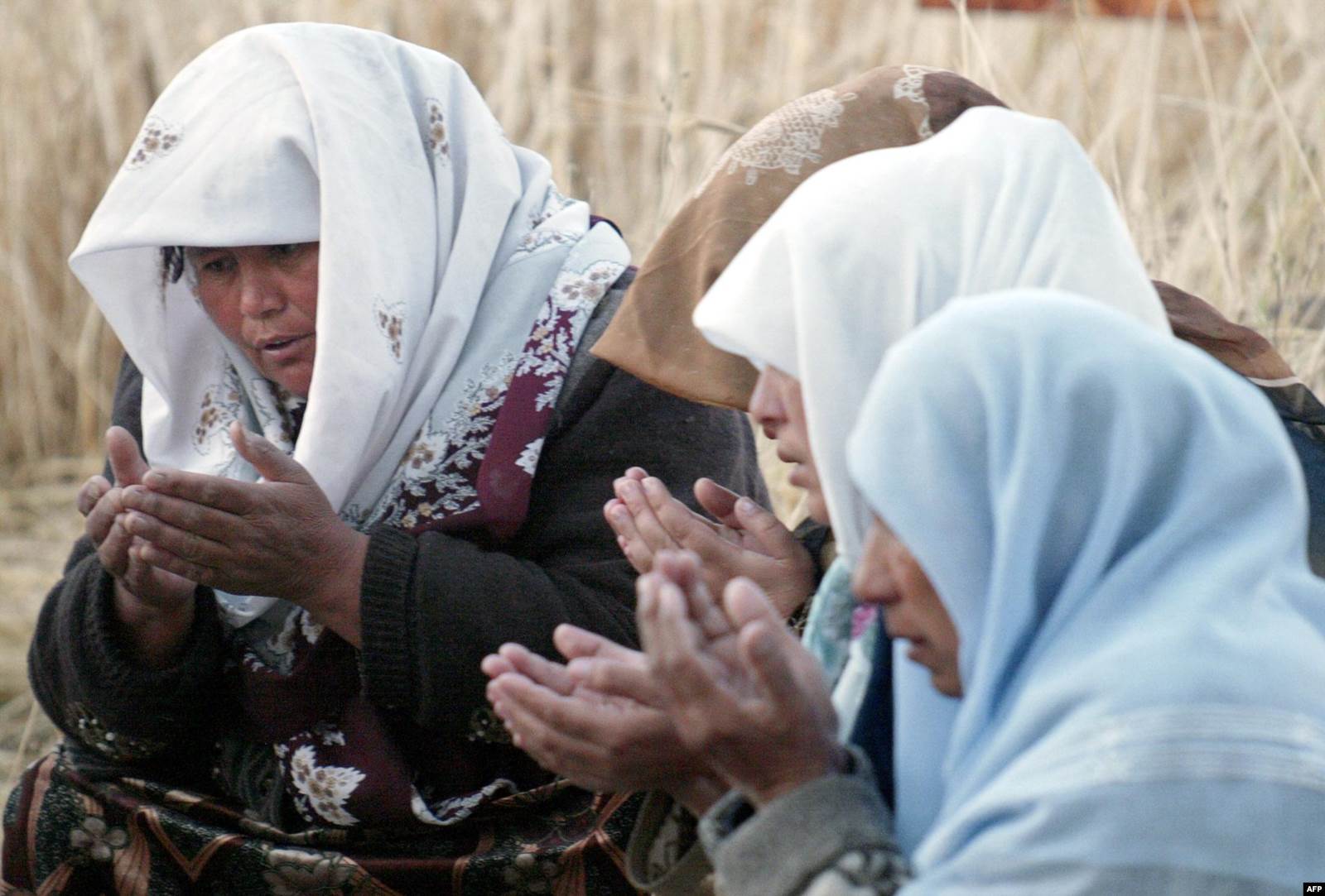 Әндіжан оқиғасында қайтыс болған марқұмның жақындары құран оқып отыр. 17 мамыр 2005 жыл.