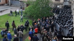 Ukrainian Interior Ministry troops stand in formation as pro-Russian supporters gather in the courtyard of the regional administration building during an attack by activists on the building in Luhansk on April 29.