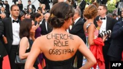 «دنبال نقش می‌گردم، با من تماس بگیرید» نوشته ای با حروف درشت بر پشت خانم جوانی در فستیوال کن