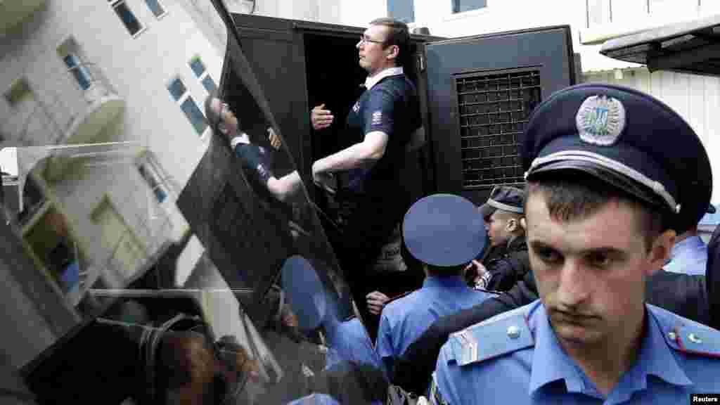 Former Ukrainian Interior Minister Yuriy Lutsenko (back) gets into a police truck after a court session in Kyiv on August 17. Lutsenko, a close ally of jailed opposition leader Yulia Tymoshenko, was sentenced to two years in prison for negligence in his second trial this year, according to local media. (Reuters/Anatolii Stepanov)