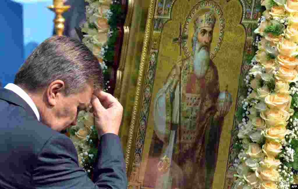 Ukrainian President Viktor Yanukovych crosses himself in front of an icon during a service and ceremony in Kyiv on July 27.