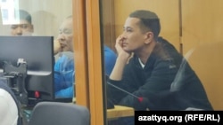 Kazakh journalist Daniyar Adilbekov (right) in a courtroom in Astana on October 16