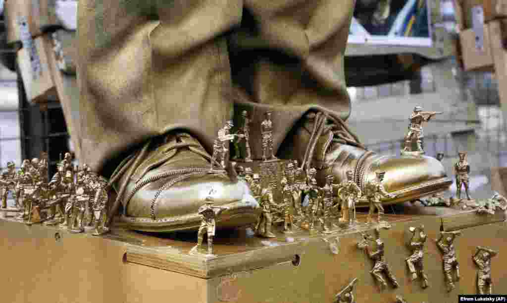 The shoes of a figure depicting Russian President Vladimir Putin are photographed surrounded by soldier figurines in front of the Russian Embassy, as right-wing activists attempt to block access for Russian citizens who live in Ukraine to vote on March 18. (AP/Efrem Lukatsky)