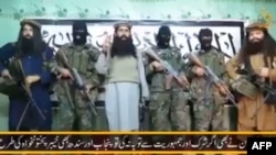 A video released by a faction within the Pakistani Taliban on January 22 shows their leader, Umar Mansoor (center), with militants delivering a statement from an undisclosed location.