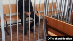 A defendant awaits trial at a Dushanbe court. Rights groups and international monitors have long maintained that the Tajik justice system is often used by authorities as a means of punishing activists and oppositionists. (file photo)