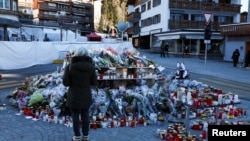 O femeie aduce un omagiul victimelor din localul elvețian la Constellation, care a ars în timpul petrecerii de Anul Nou.