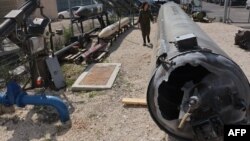 A member of the Israeli military walks past an Iranian ballistic missile which fell in Israel during a media tour on April 16 at the Julis military base near the southern Israeli city of Kiryat Malachi.