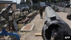 A member of the Israeli military walks past an Iranian ballistic missile which fell in Israel during a media tour on April 16 at the Julis military base near the southern Israeli city of Kiryat Malachi.