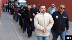 Suspected supporters of Fethullah Gulen are escorted by plainclothes police officers as they arrive at police headquarters in Kayseri in April 2017.