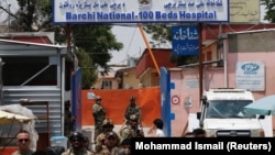 Afghan security forces stand guard outside the Dasht-e-Barchi hospital in Kabul following a deadly attack on May 12. 