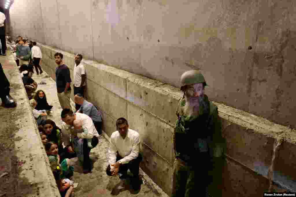 Israelis shelter in a ditch amid the October 1 attack.&nbsp; Two Israeli air bases were targeted in the strikes and some missiles landed near the headquarters of the Mossad spy agency in Tel Aviv.&nbsp;