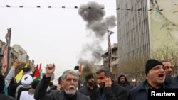 Тегеранда митинг өтіп жатқан шақта жақын жерде қою түтін көтерілді. 13 наурыз 2026 жыл.