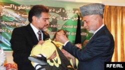 Afghan President Hamid Karzai (right) administered a polio vaccine to a child in Kabul as part of a public-awareness campaign in 2009.