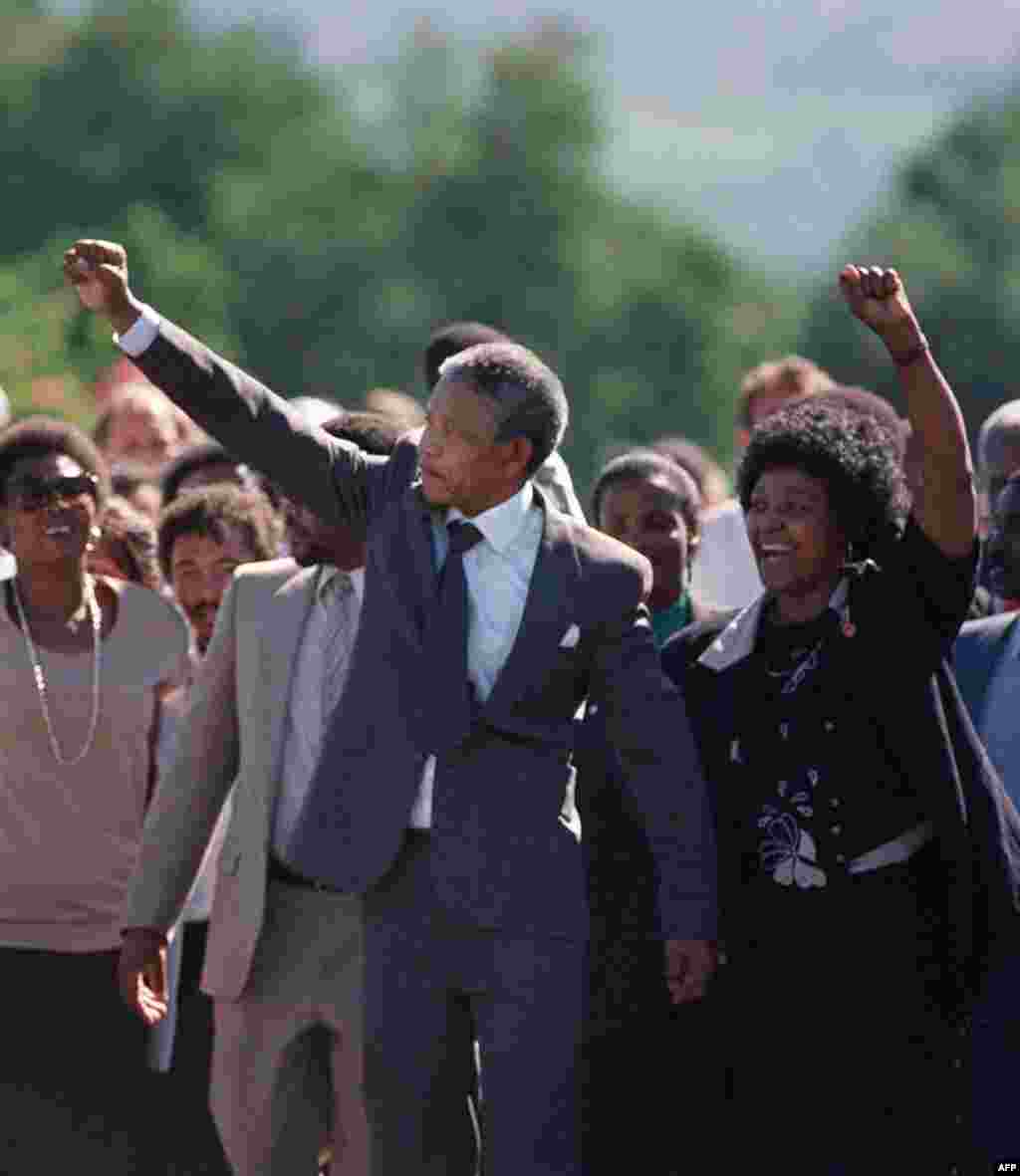 Nelson and Winnie Mandela raise their fists and salute a cheering crowd upon Nelson&#39;s release from prison after 27 years.