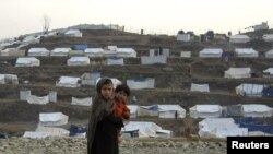 Siblings fleeing a military offensive in the Bajaur tribal agency stand in front of the Walikandawe camp for the internally displaced in Lower Dir district last year.