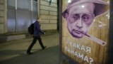 A man walks past a poster depicting Russian President Vladimir Putin and reading "Which Panama?" at a bus stop in Moscow on April 6.