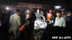 Пакистанские спасатели переносят на носилках тела погибших при взрыве бомбы в Лахоре, 27 марта 2016 года.