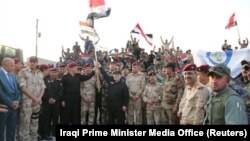 Հայդեր ալ-Աբադին, Իրաքի դրոշը պարզած, հայտարարում է ԻՊ-ի նկատմամբ տարած հաղթանակի մասին, 10-ը հուլիսի, 2017թ.